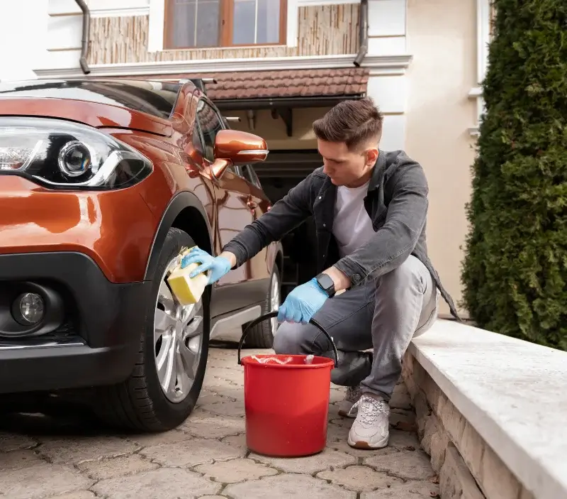 Lavage auto à domicile Varrains : professionnel intervenant sur un véhicule